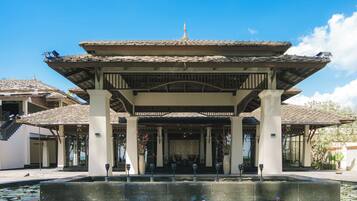 A traditional building with a tiled roof and a central courtyard with a water feature and lotus plants.