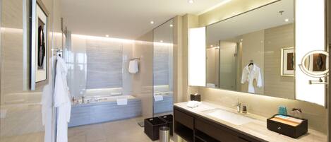 Une salle de bain moderne avec un grand miroir, une baignoire et un meuble-lavabo.