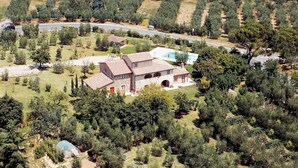 Una casa grande con un patio amplio, piscina y un jardín cuidado.