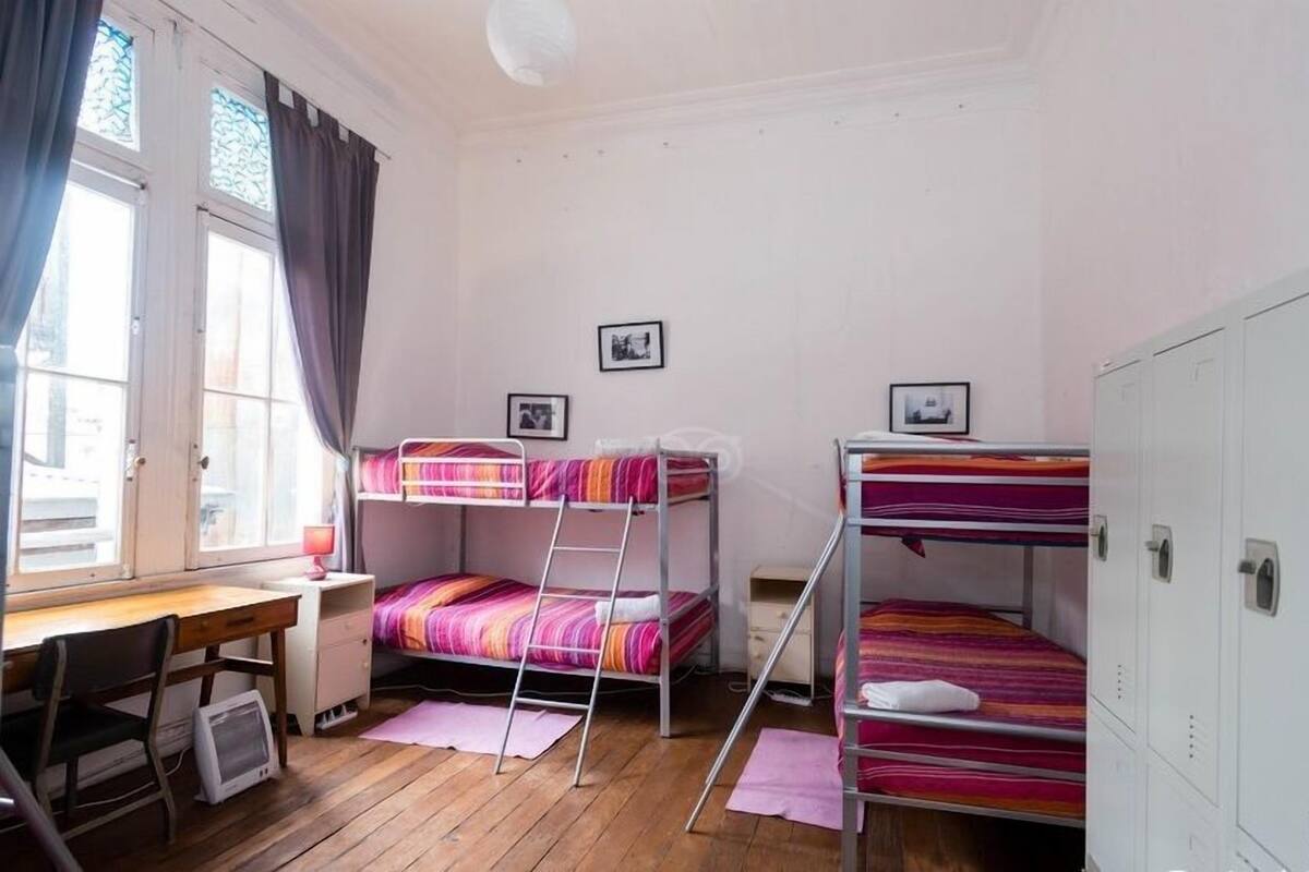 Une chambre de dortoir équipée de lits superposés, d’un bureau, d’une chaise et d’une armoire.