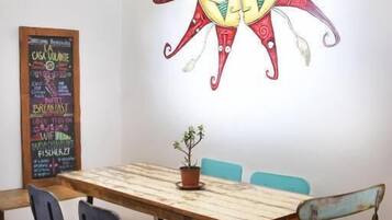 A dining area with a wooden table, four chairs, and a wall mural.