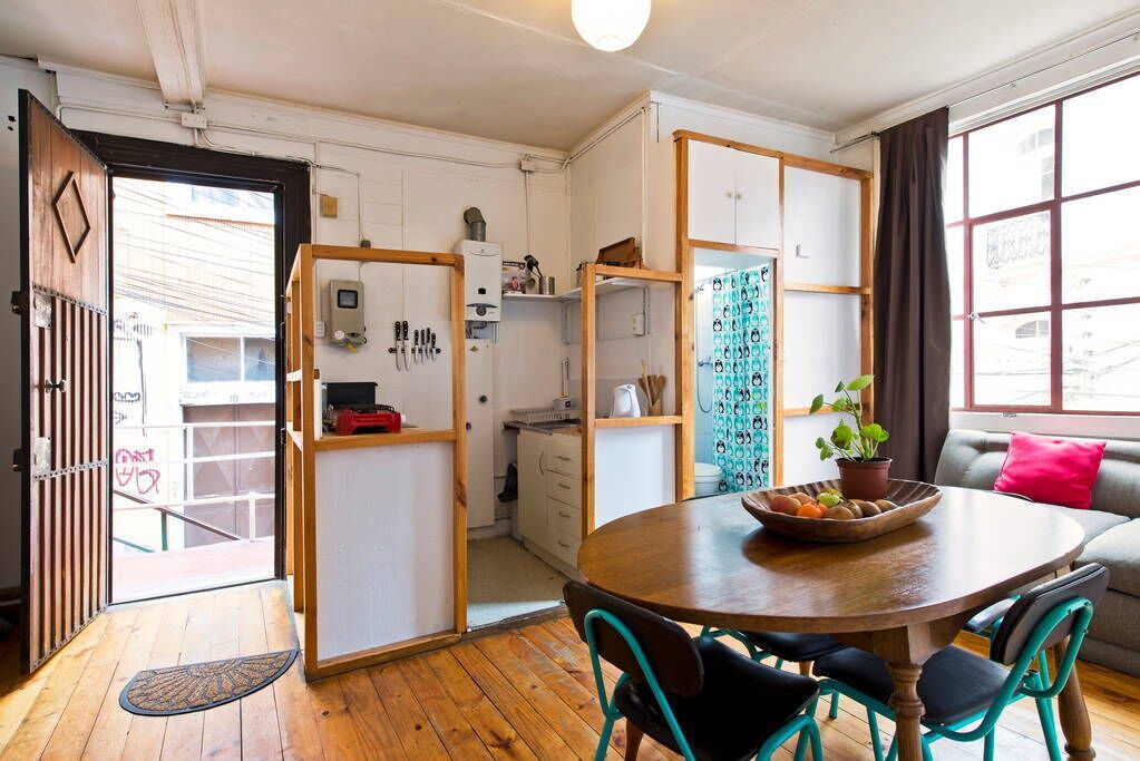 A compact living space with a dining area, kitchenette, and a sofa.