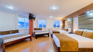 A hotel room with three beds, a TV, and large windows offering city views. - Hotel Metropolis Plaza (Cali)