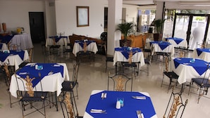 A dining area with tables set for service, chairs, and a potted plant. - Hotel Metropolis Plaza (Cali)