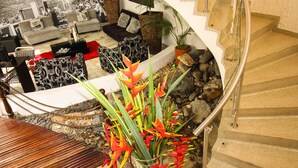 Un espacio de estar moderno con un sofá, una mesa de centro y plantas decorativas.