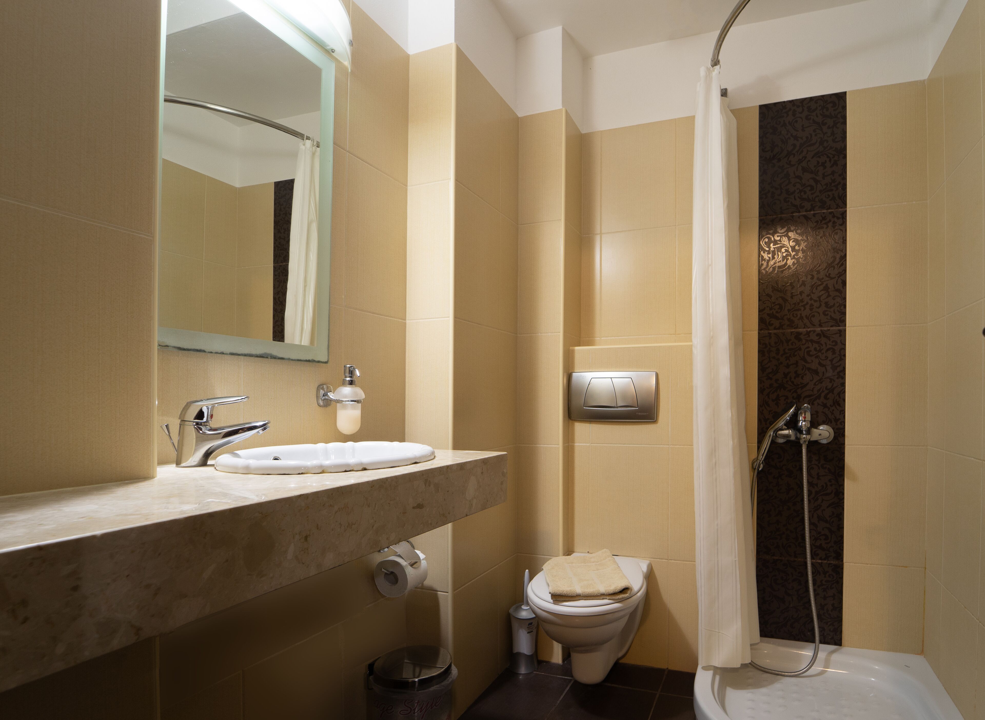 A bathroom with a sink, toilet, and shower.