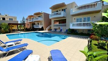 Relax by the pool surrounded by comfortable lounge chairs and lush greenery.