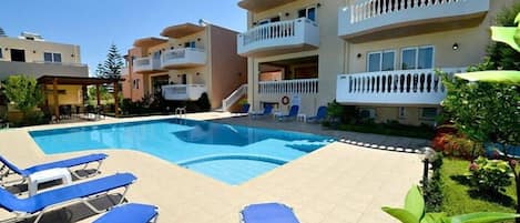 Een seizoensgebonden buitenzwembad, parasols voor strand/zwembad