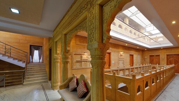 A grand lobby with a marble floor, a staircase, ornate columns, and a glass ceiling. - Hotel Sky Plaza (Jaisalmer)