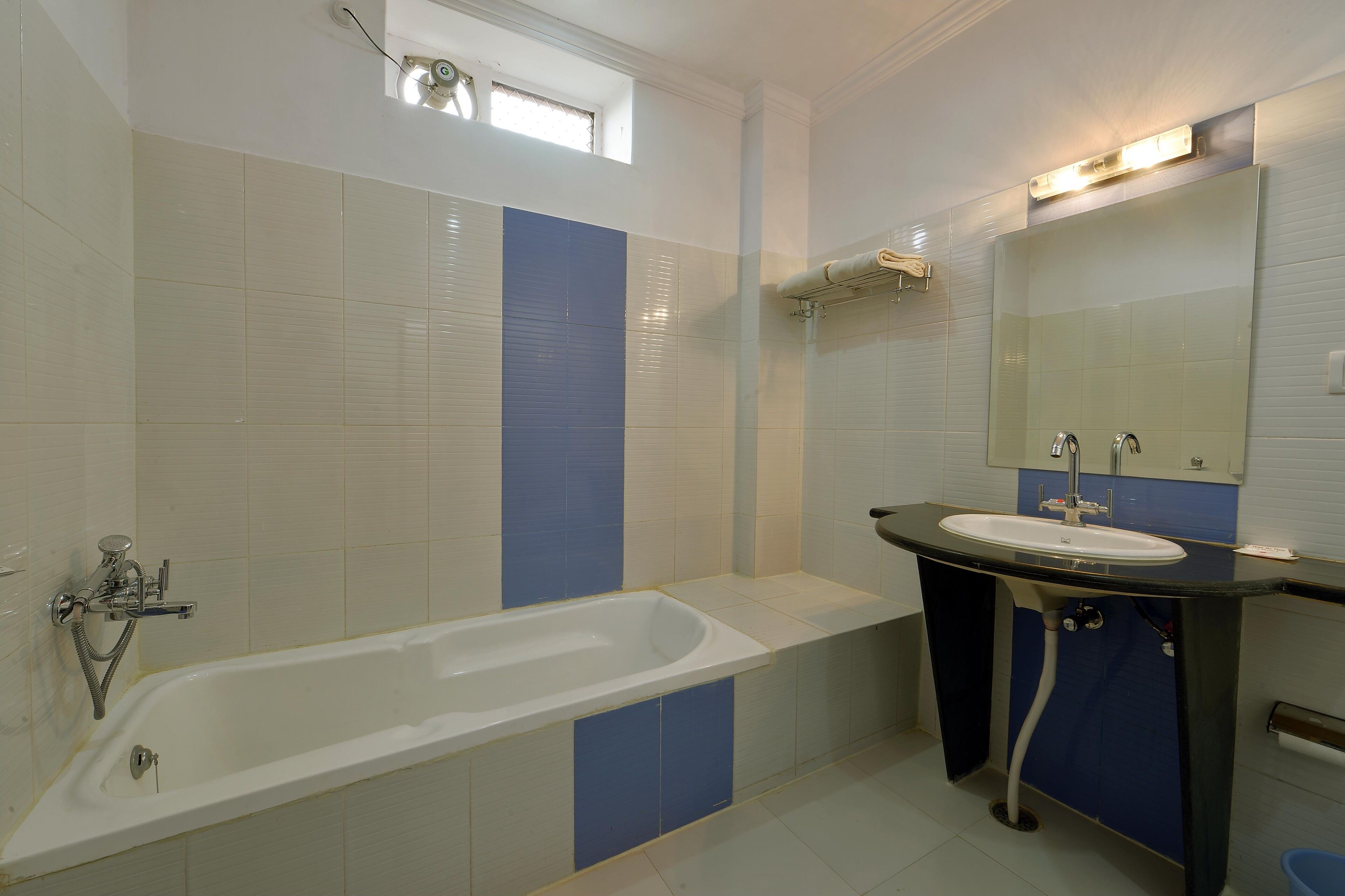 A bathroom with a bathtub, sink, and mirror.