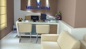 Un área de recepción con mostrador, dos sillas, un sofá y un árbol de Navidad.