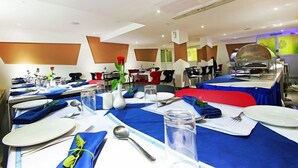 Comedor con mesas dispuestas para el servicio, incluyendo platos, cubiertos y servilletas.