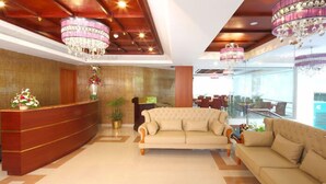 A hotel lobby with a reception desk, two sofas, and chandeliers. - Cochin Palace (Kanayannur)