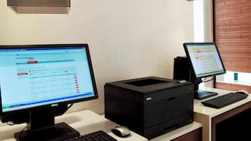 A workspace with two computer monitors, a keyboard, and a printer.