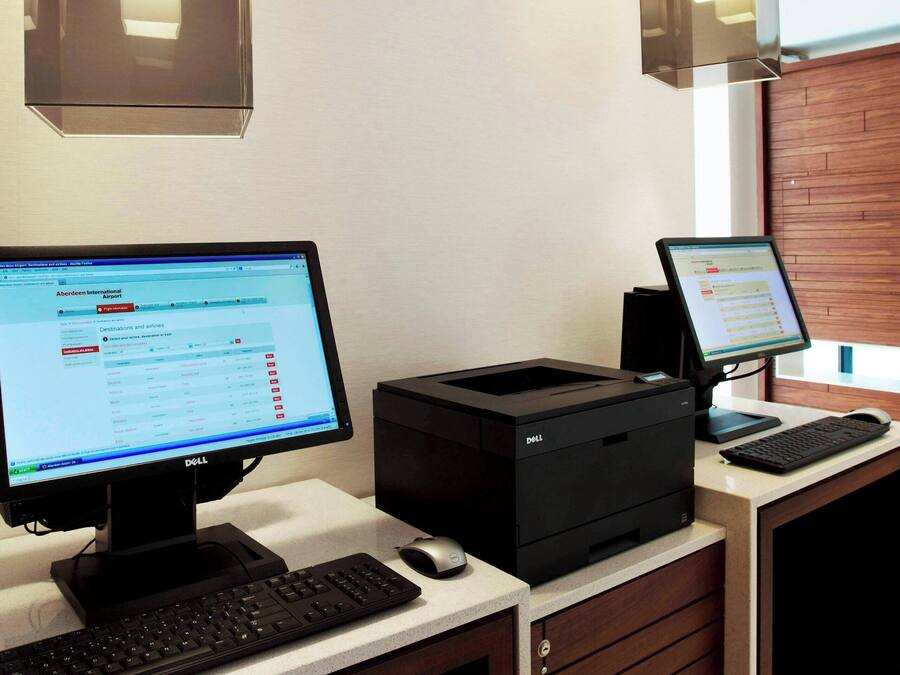 A workspace with two computer monitors, a keyboard, and a printer.