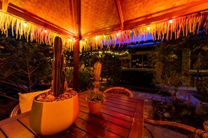 A patio area with a wooden table, two potted plants, and a cactus. - The Desoto Inns (Hollywood)