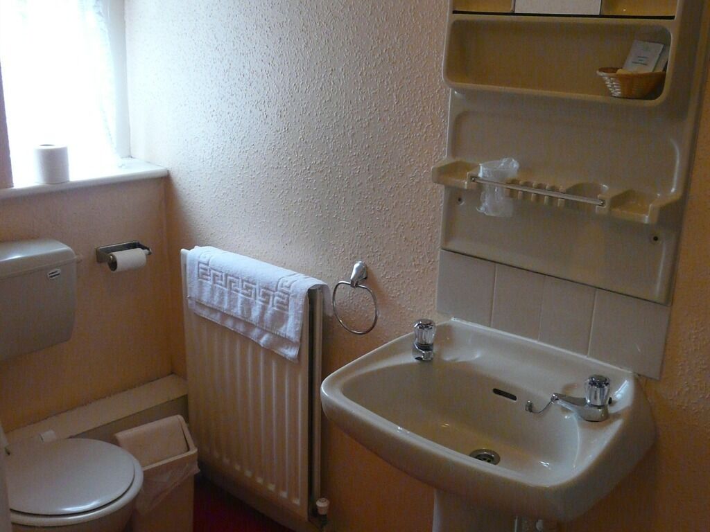 A small bathroom with a toilet, a sink, and a towel rack.