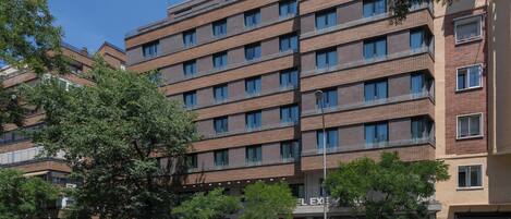 A multi-story hotel with a modern design, featuring a uniform facade with evenly spaced windows and balconies.