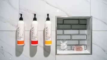 Tres botellas de gel de ducha PAYA y una pequeña vitrina con un producto PAYA.