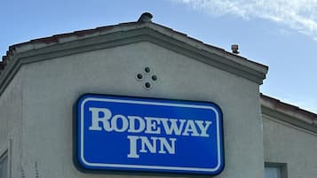 Een bordje voor Rodeway Inn op een buitenmuur van een gebouw.