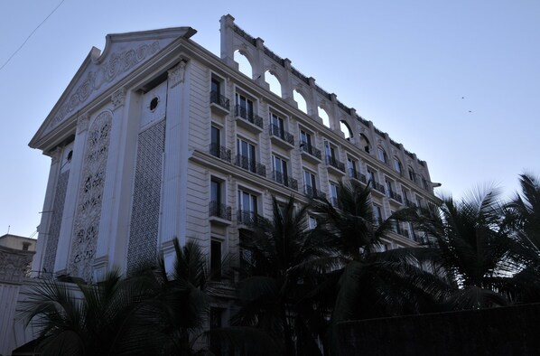 Un immeuble à plusieurs étages, doté d’éléments architecturaux raffinés, notamment des colonnes et des balcons décoratifs.