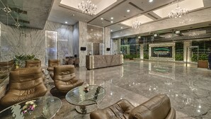 A modern lobby with leather sofas, a glass coffee table, and a reception desk. - Goldfinch Hotel Mumbai (Mumbai)