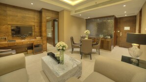 A modern hotel lobby with a marble coffee table, comfortable seating, a reception desk, and a decorative wall. - Goldfinch Hotel Mumbai (Mumbai)