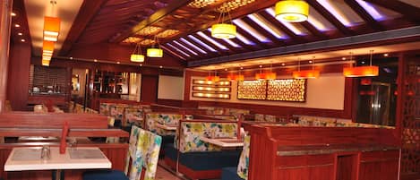 A restaurant interior with booths, tables, and hanging lights.