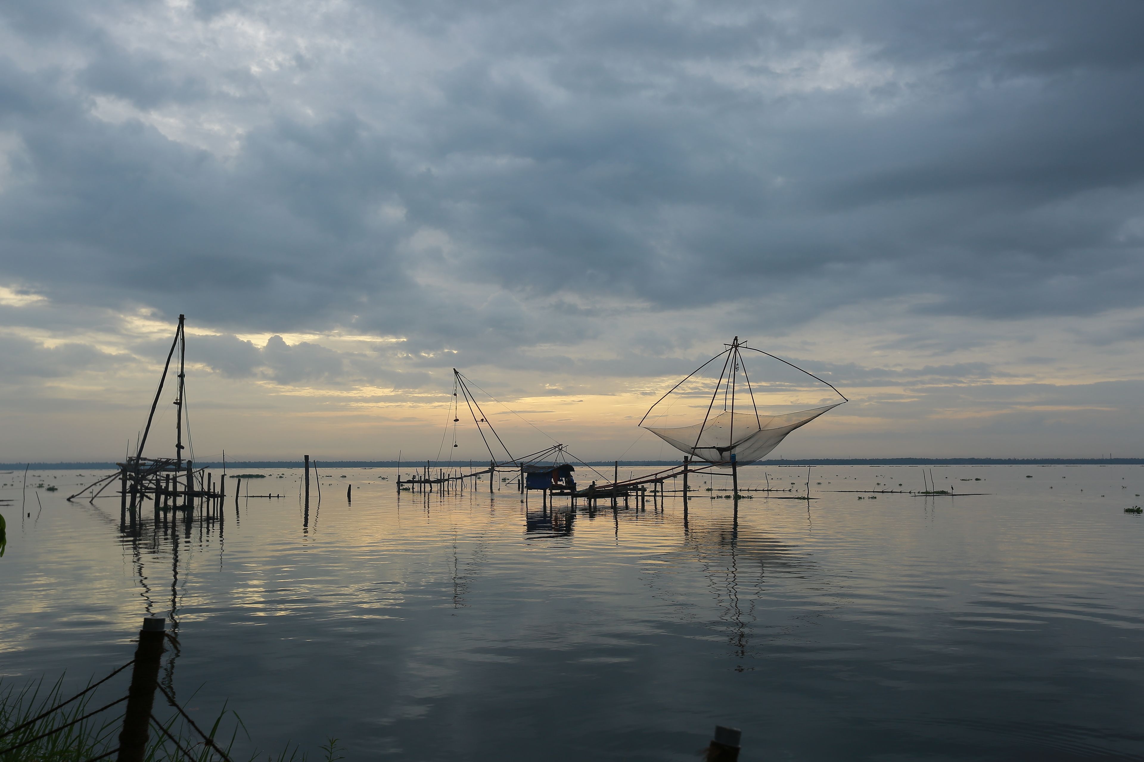 A calm water body with fishing nets and structures.