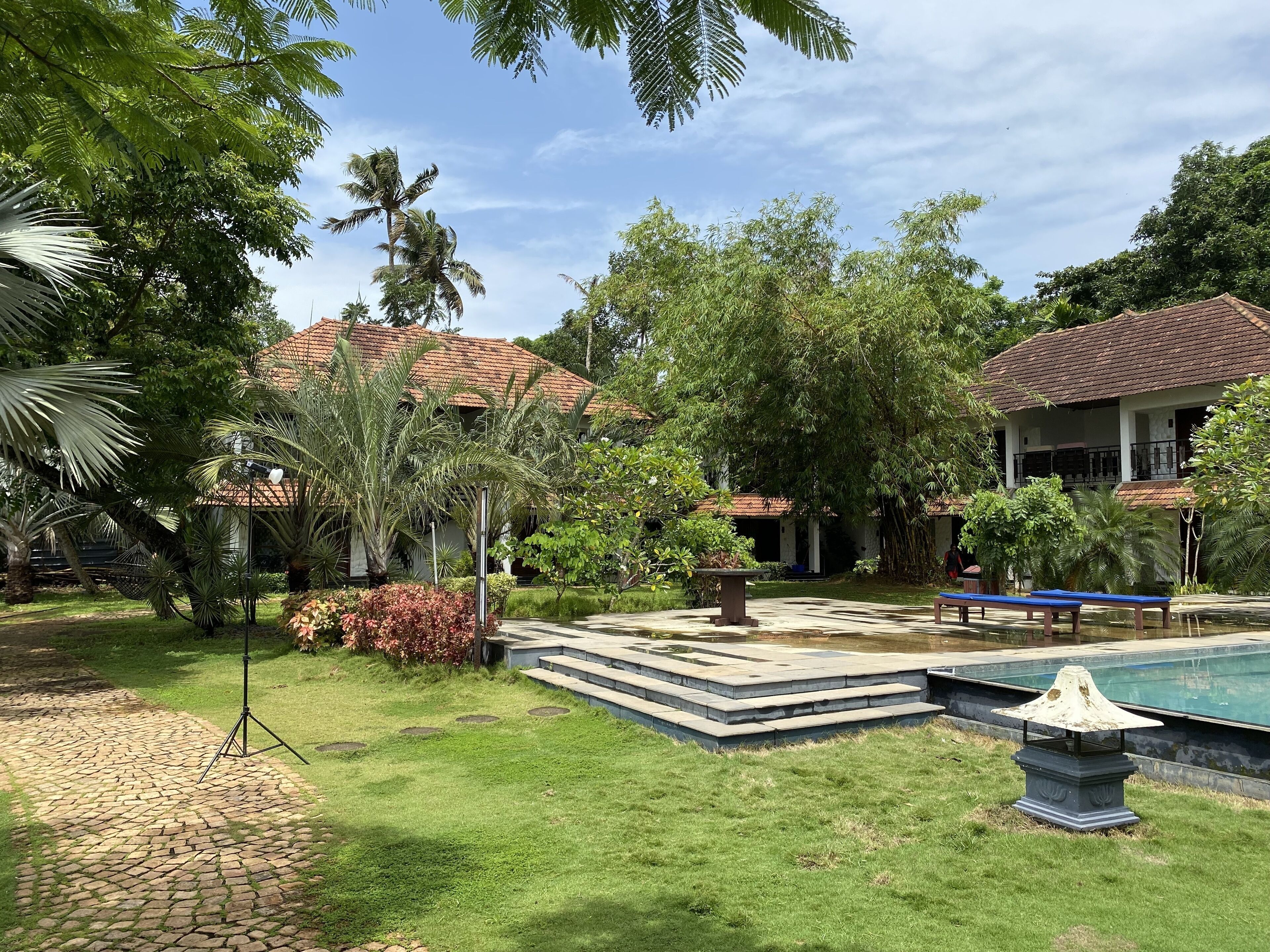 A courtyard with a swimming pool, stone steps, and a gazebo.