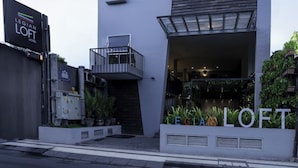 A modern building with a prominent sign for "LEGIAN LOFT HOTEL" and "EGIA LOFT." It features a flat roof, a balcony, and a large entrance with a glass facade. - Loft Legian Hotel (Legian)