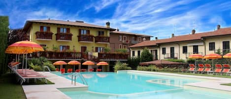 Piscina a l'aire lliure de temporada, para-sols i gandules