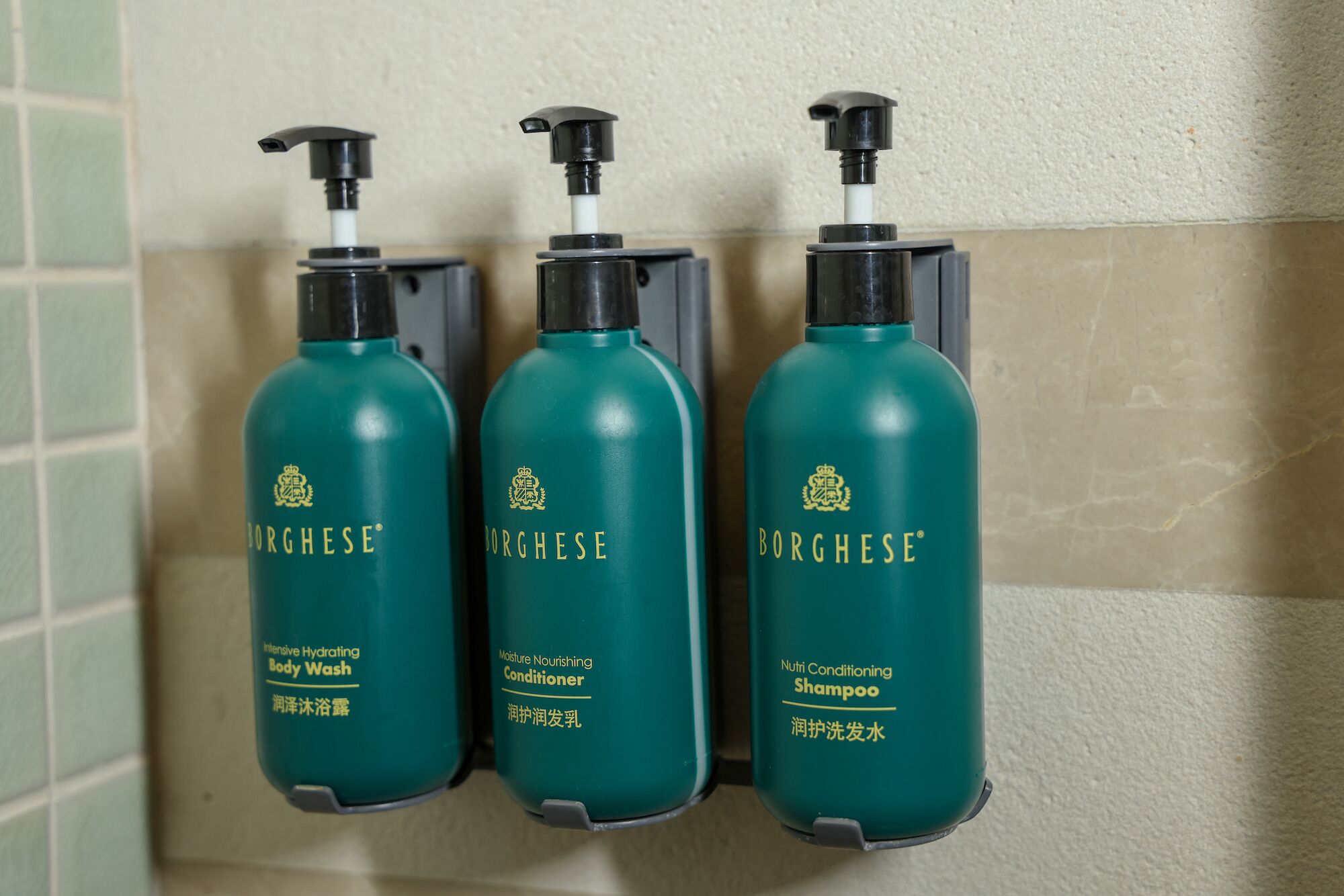 Three Borghese body wash bottles mounted on a wall.