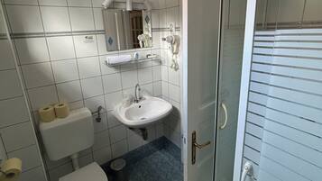 Un baño con inodoro, lavamanos y espejo.