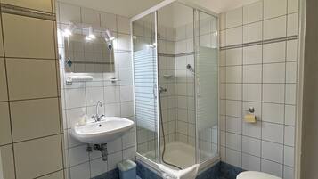 Une salle de bain avec une douche à parois de verre, un lavabo et des toilettes.