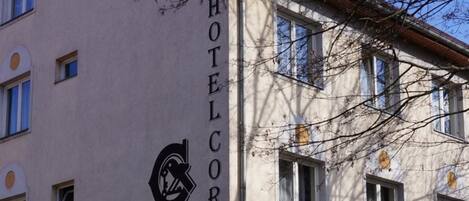A hotel named "Hotel Corvin" with a sign indicating a parking area.