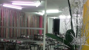 Un ristorante con una parete a specchio e un'orchidea in vaso.