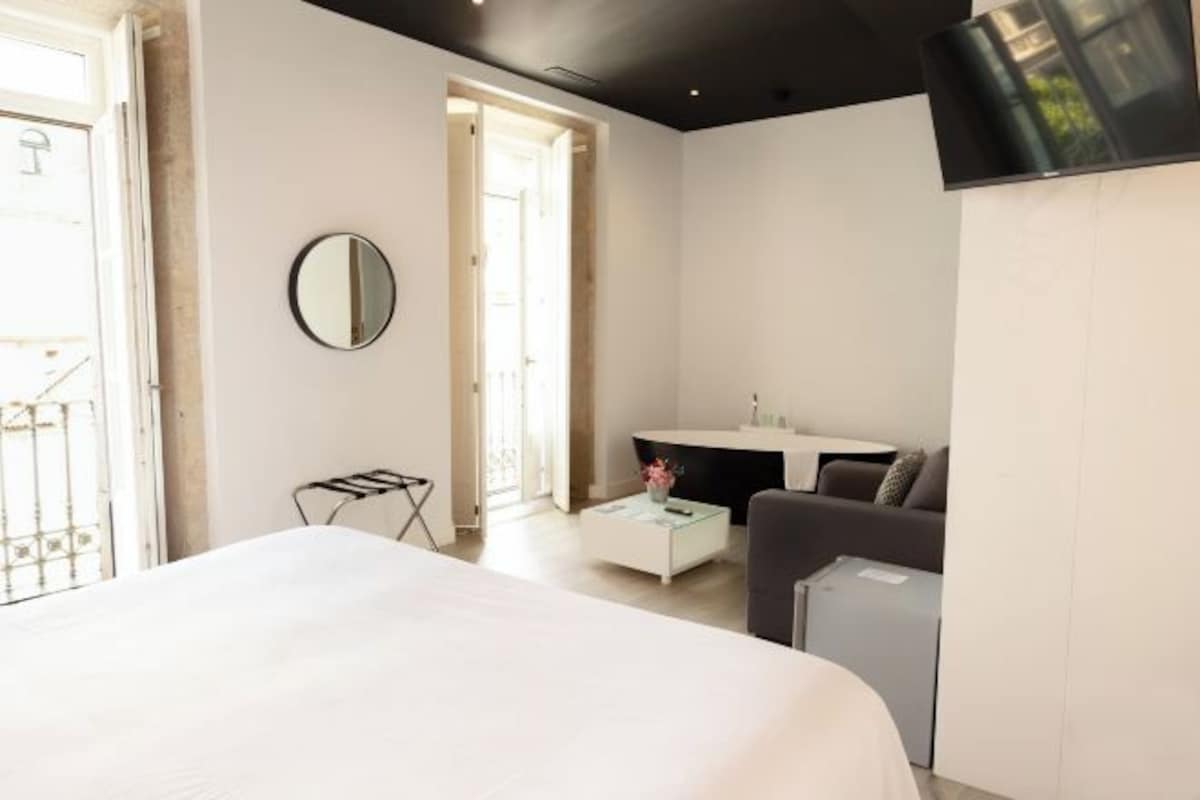 Un dormitorio moderno con una cama grande, un escritorio, una silla y un espejo.
