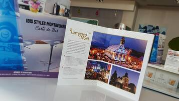 Un folleto con texto e imágenes de un mercado navideño, que incluye un edificio con torre del reloj y luces festivas.