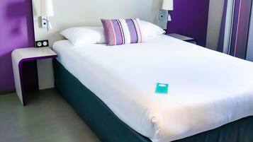 Una camera d'albergo con un letto grande, due comodini, una testiera e lampade a parete.