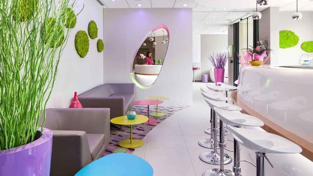 Un interior moderno con mostrador de recepción, zona de estar y bar.