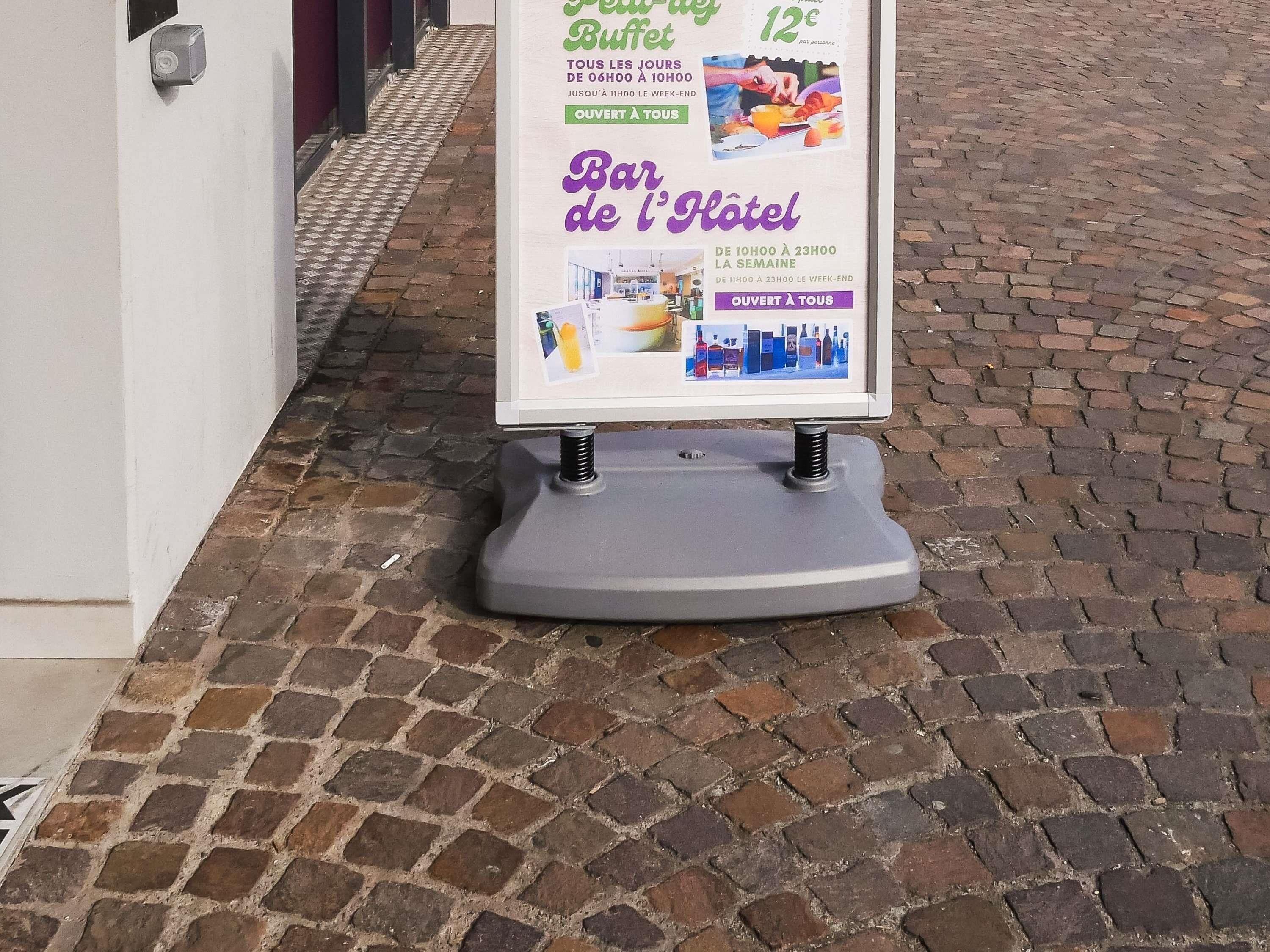Ein Schild mit einer Restaurant- und Hotelanzeige, inklusive Öffnungszeiten und Preisen.