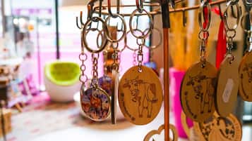 A display of wooden keychains with cow designs, hanging on a metal rack.