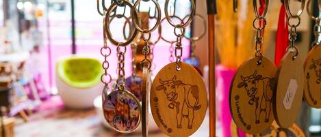 Un expositor con llaveros de madera con diseños de vaca, colgados en un perchero metálico.