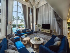 Un salon spacieux, doté d’un grand canapé, d’un téléviseur à écran plat et offrant une vue sur une piscine.