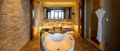 Une salle de bain moderne avec une grande baignoire, un mur en pierre et un plafond en bois.