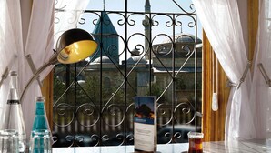Una mesa con una lámpara, una cerveza, un menú y botellas de agua y refrescos.