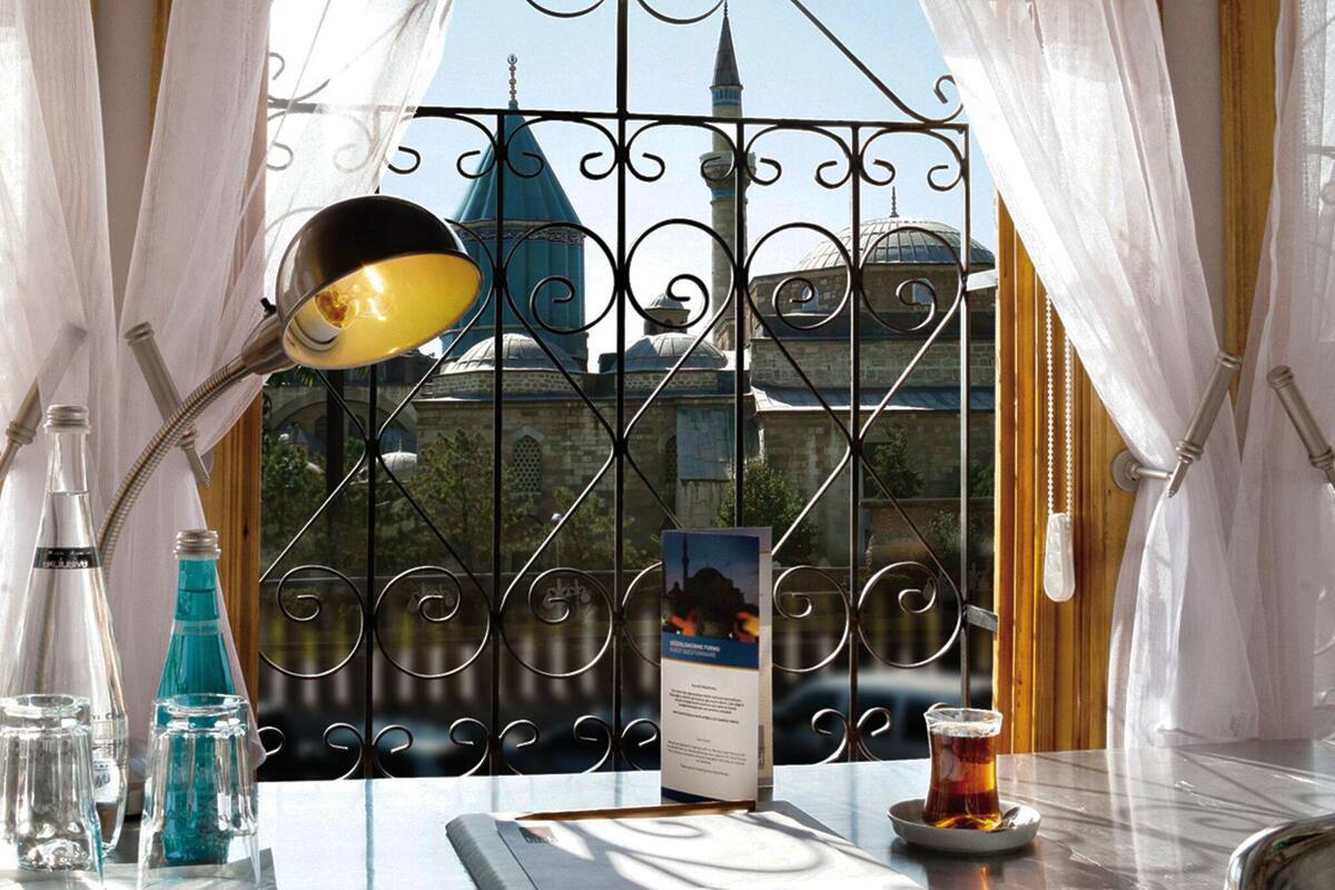 A table with a lamp, a glass of beer, a menu, and bottles of water and soda.