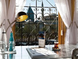 Una mesa con una lámpara, una cerveza, un menú y botellas de agua y refrescos.