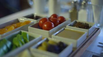 Un bufé de desayuno con diferentes alimentos en recipientes separados.